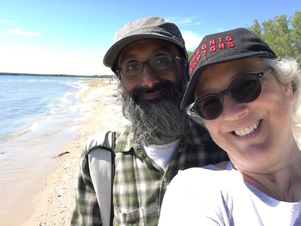 Aruna and her husband parampreet at the beach with the shorline stretching for miles behind them at Sandbanks Provinicial Park in Ontario Canada. 
