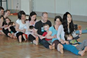 family yoga, families doing a rowing arms pose that can be used in an Olympic themed lesson plan