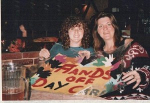 two women hold a sign that says "hands off daycare" at the International Womens Day 1995