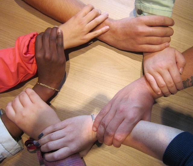Circle of hand holding of various skin shades