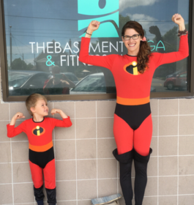 Marcia with her son are dressed as superheroes to put the Super Hero into Kids Yoga.